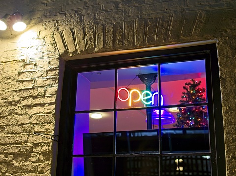Neon open sign in window of shop near Charleston market place in old town.