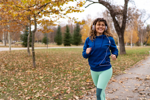 istock Young woman running in autumn park 1877831245