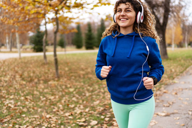 istock Young woman running in autumn park 1877832310