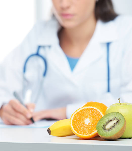istock A Nutritionist Doctor writing notes next to some fresh fruit 187784770