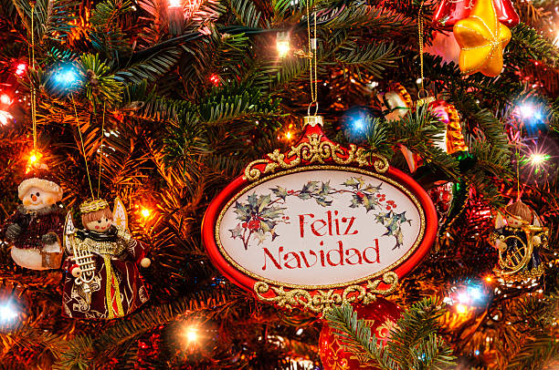 Christmas tree with Feliz Navidad ornament Christmas tree with lights and colorful ornaments.  Ornament with Feliz Navidad navidad stock pictures, royalty-free photos & images