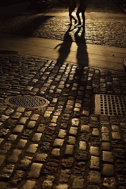 istock Two young people walking in amber night shadows 187785251