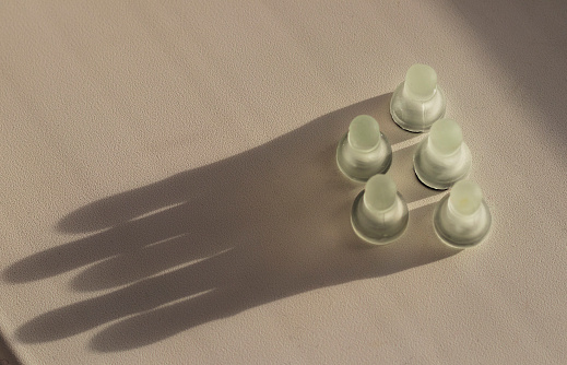 Shot of the chess pieces, pawns, casting shadow in the shape of a crown