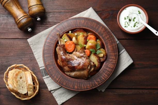 istock Tasty cooked rabbit meat with vegetables served on wooden table, flat lay 1877869022