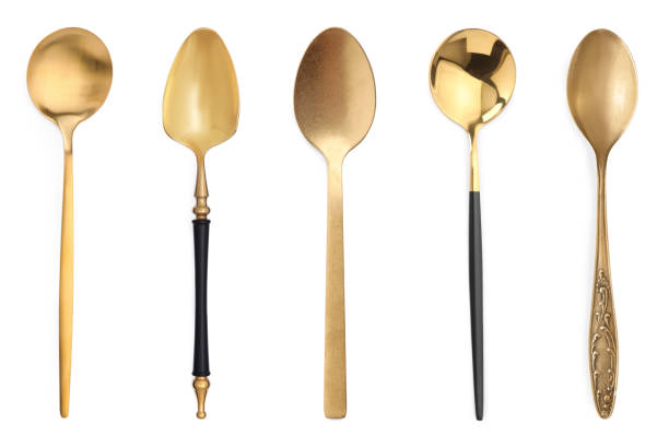 Different stylish golden spoons on white background