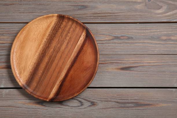 istock One plate on grey wooden table, top view. Space for text 1877878514