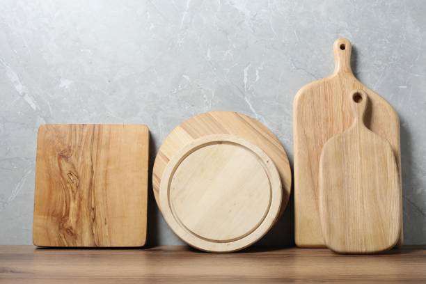 istock Different wooden cutting boards on table near gray wall 1877879331