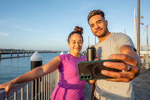 Young polynesian individuals taking a photo with a smart phone