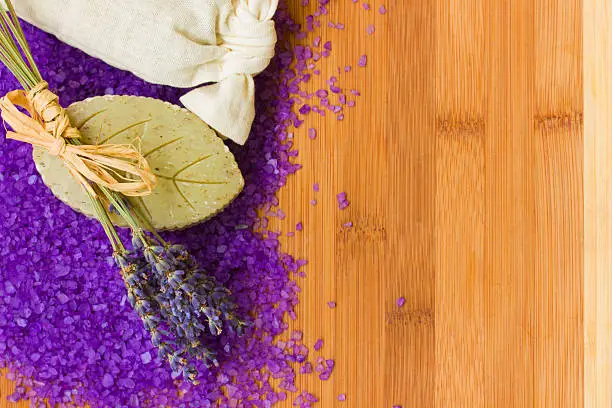 dry lavender with bath salt and soap on wooden table