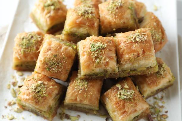 istock Delicious fresh baklava with chopped nuts on plate, closeup. Eastern sweets 1877921193