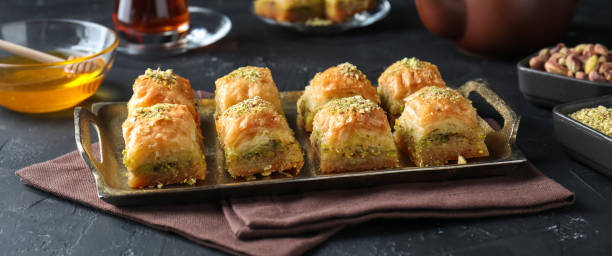 istock Delicious fresh baklava with chopped nuts served on grey textured table, closeup. Eastern sweets 1877924809
