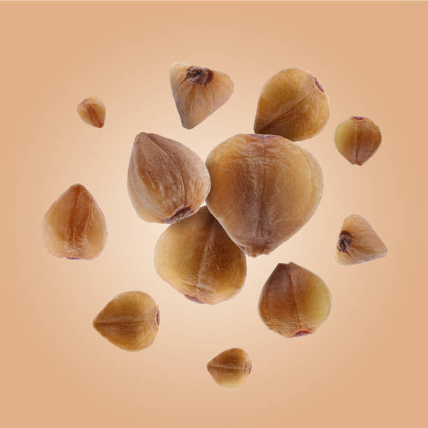 istock Buckwheat flying on light orange background. Grains in air 1877925308