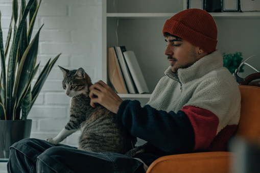 young man at home with pet cat