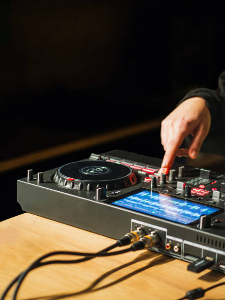 istock Hand of a DJ mixing music tracks on DJ controller with a black background. 1877932012