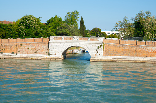 Low Brick  arch bridge with lion on island of Lido, Venice