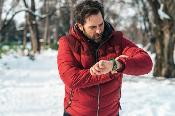 istock Man in red winter jacket looking at his wrist watch 1877957627