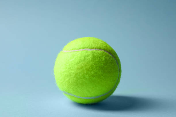 istock One tennis ball on light blue background 1877960208