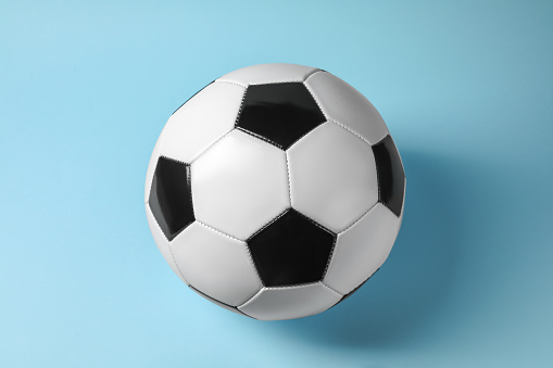 One soccer ball on light blue background. Sports equipment