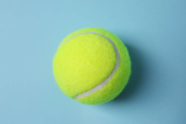 istock One tennis ball on light blue background, top view 1877972162