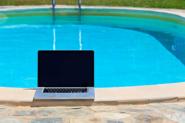 istock laptop at the pool, work on holiday concept 187798251
