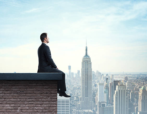 istock businessman sitting on roof 187800011