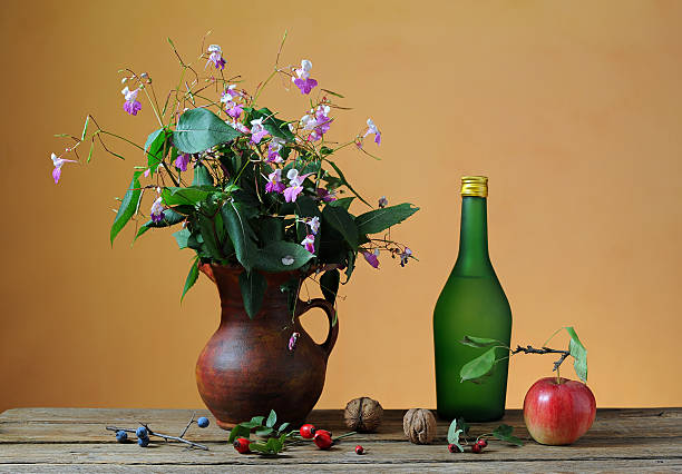 Flowers in a ceramic vase and fruit on the table