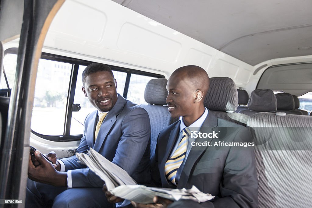 African uomini d'affari avendo una conversazione in taxi. - Foto stock royalty-free di Abbigliamento elegante