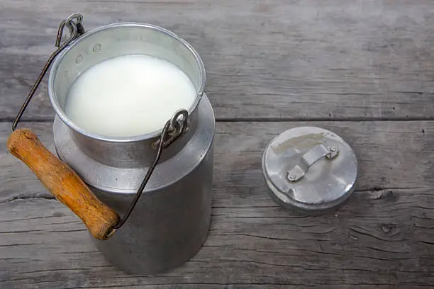 Traditional milk canister on old wood