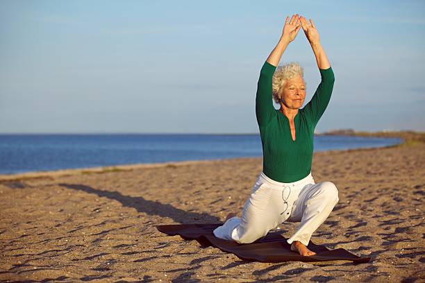 istock Senior woman stretching on the beach 187809760