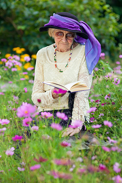 Mujer de edad avanzada en un sombrero beautitul lectura de estar. - foto de stock