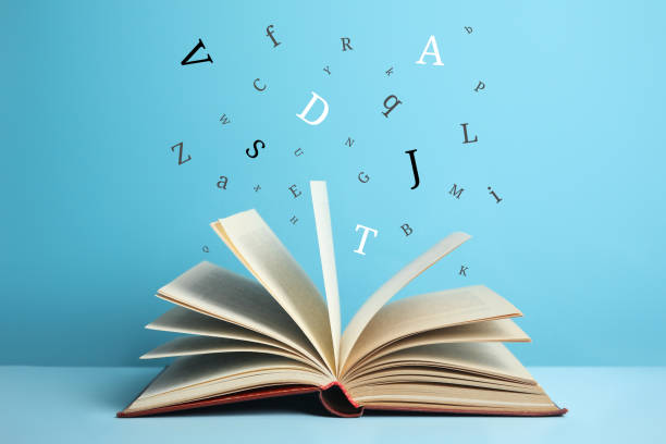 istock Open book with letters flying out of it on light blue background 1878159388