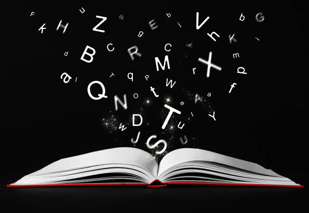 istock Letters flying out from open book on black background 1878173499