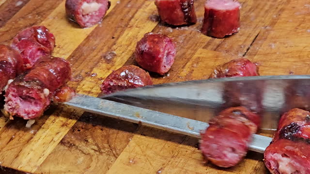 Thin sausage being removed from the skewer