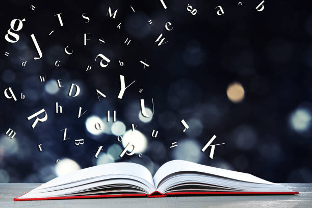 istock Letters flying out from open book on wooden table, bokeh effect 1878178568