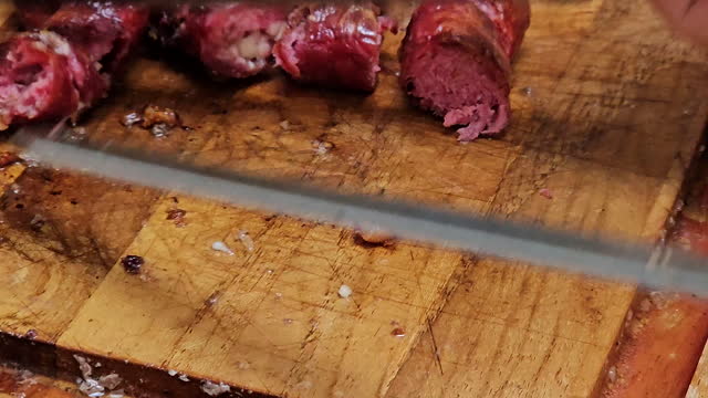 Thin sausage being removed from the skewer