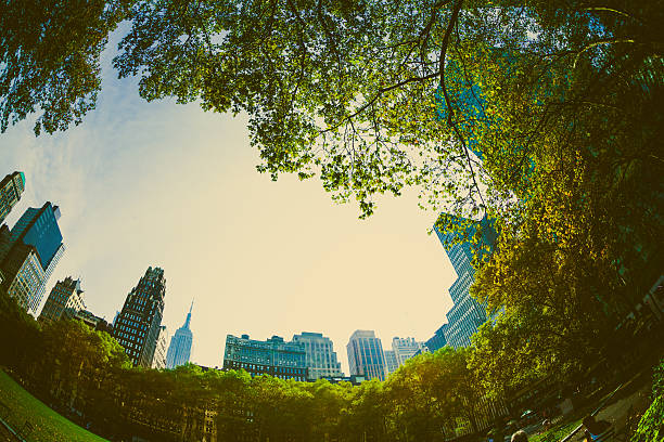 Central Park, Manhattan, NYC, USA  view of the surrounding skyscrapers from Central Park through trees.  There is  funfair in the foreground.