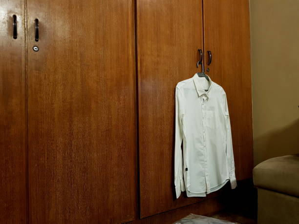 One white shirt hanging on coat hanger.