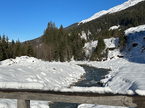 Snowy river with snow covered river banks in winter