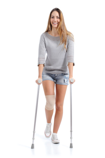 Front view of a woman walking with crutches isolated on a white background