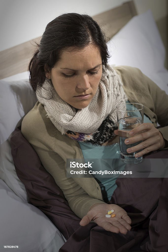 Sick woman looking at medicine pills Sick woman holding and looking at medicine pills flu cold Acetylsalicylic Acid Stock Photo