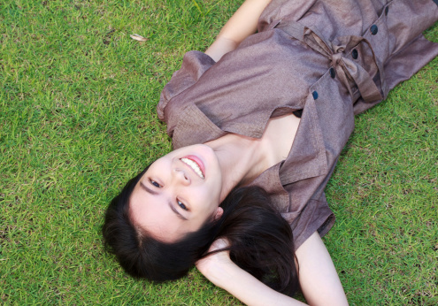 smiling woman lying on green grass