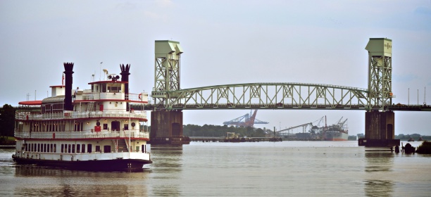 A riverboat travels upstream on the Cape Fear River in Wilmington, North Carolina with the Cape Fear Memorial bridge in the background.