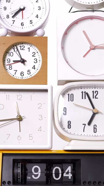 Many clocks turning to tell the time on a white background.