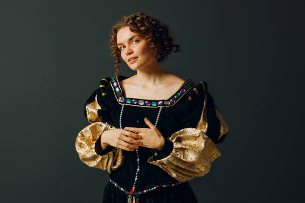 Portrait of a young aristocratic woman dressed in a medieval dress on dark background. stock photo
