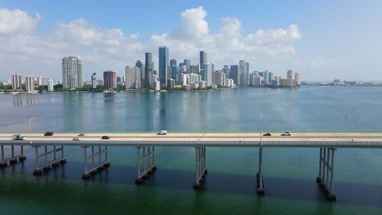 Urban landscape of downtown district of Miami Brickell in Florida with cars driving over bridge. Skyline with high skyscraper buildings in modern American megapolis
