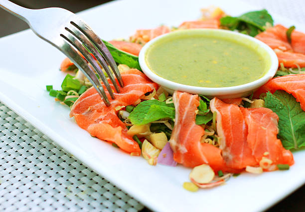 istock Spicy salmon salad and wasabi sauce with fork 187838625