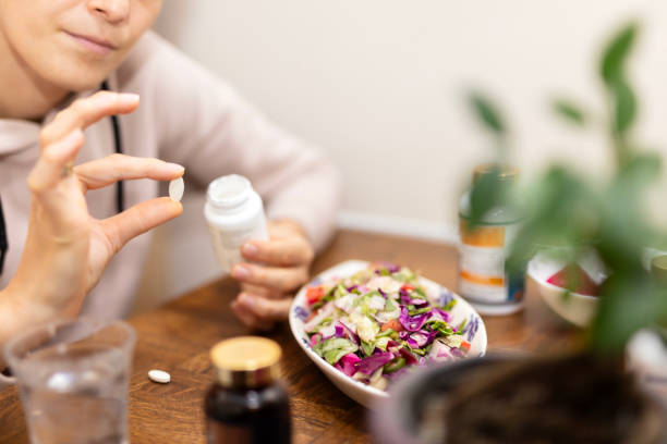 woman is taking pill with laptop 스톡 사진