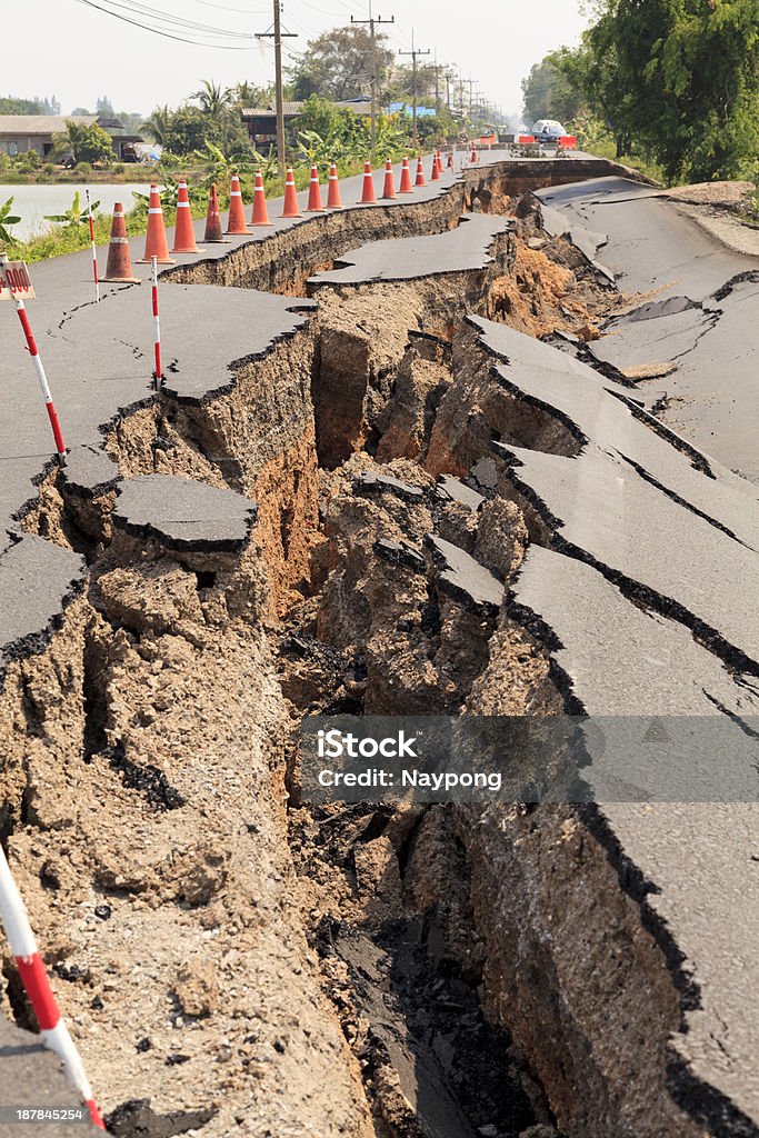 Cracked asphalt road revealing dirt Cracked asphalt road Earthquake Stock Photo