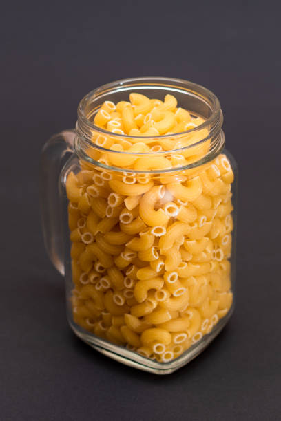istock Uncooked Chifferi Rigati Pasta in Glass Jar on Black Background 1878507715