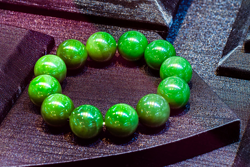 Different natural stone beads on a white background, close-up, free space for text. Many bracelets made of various natural stones, copy space.